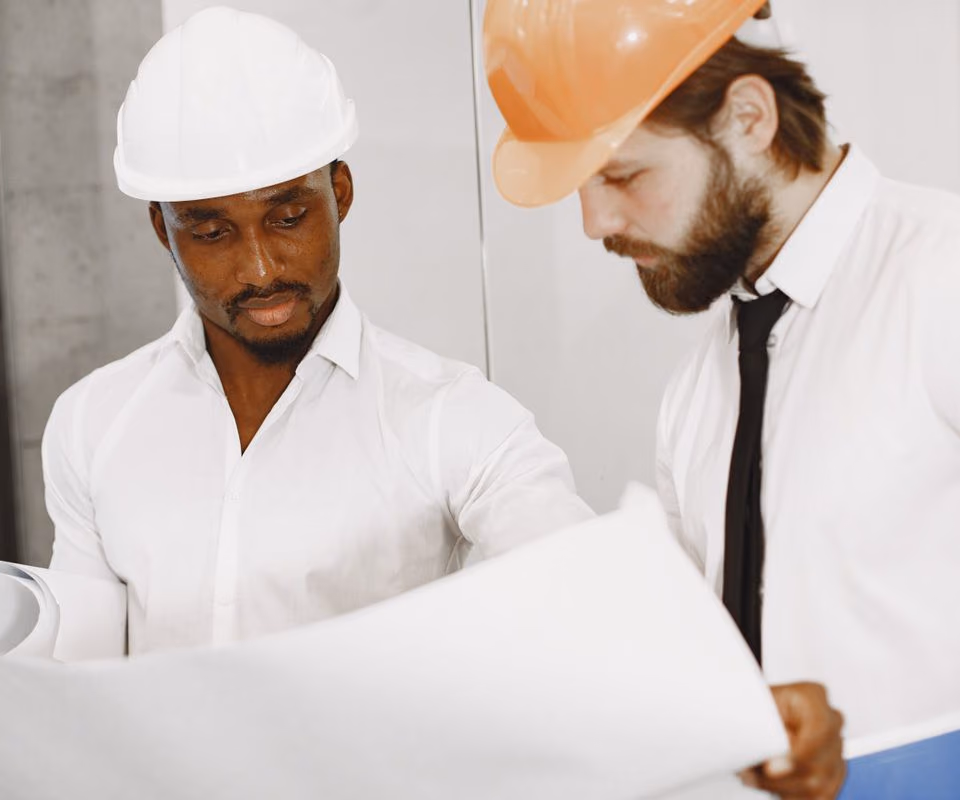 Deux professionnels casqués échangent autour de plans avant une intervention. Photo d’illustration.